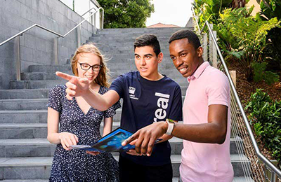 a QUT student ambassador directing a male and female with map directions