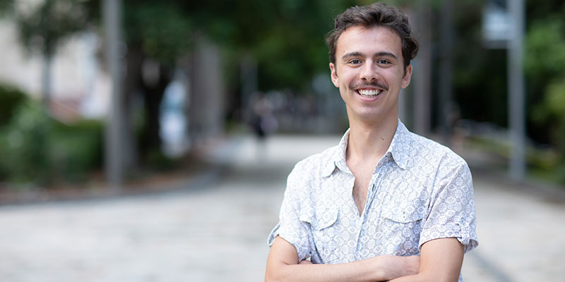 Male student on campus smiling at camera 